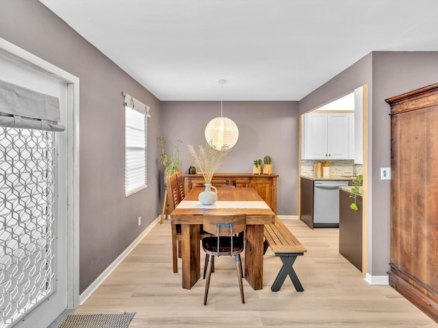 dining space with baseboards and light wood finished floors