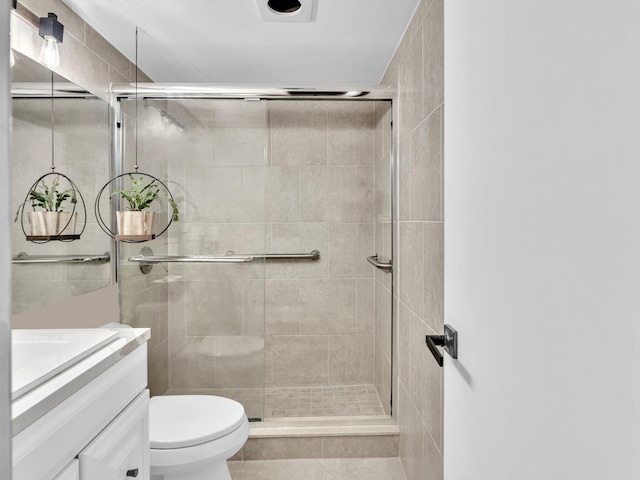 bathroom featuring vanity, an enclosed shower, and toilet