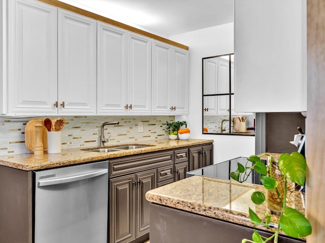 kitchen featuring tasteful backsplash, a sink, white cabinets, and stainless steel dishwasher