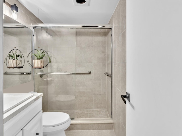 bathroom with vanity, toilet, and a stall shower