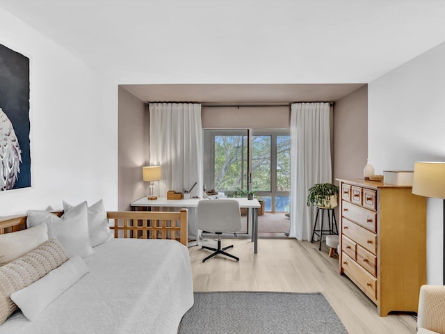 bedroom featuring access to exterior and light wood-style floors