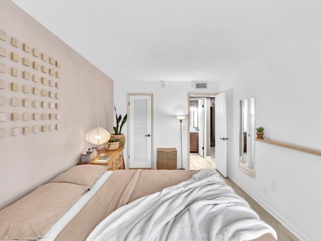 bedroom with baseboards and visible vents