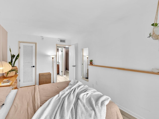 bedroom with light wood-style flooring and baseboards