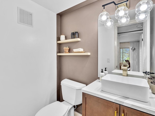 bathroom featuring visible vents, toilet, and vanity