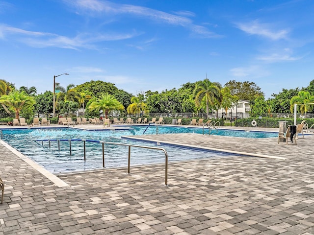 community pool featuring a patio and fence