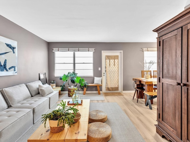 living area with light wood-style flooring and baseboards