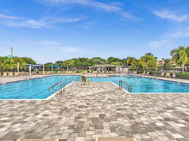 community pool with a patio and fence