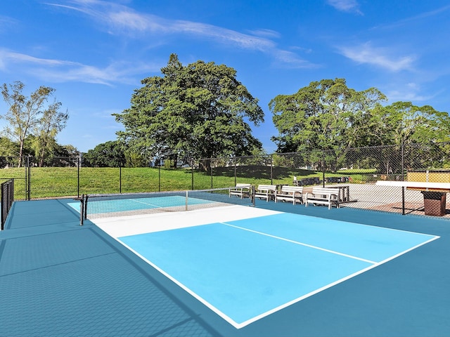 view of tennis court featuring fence