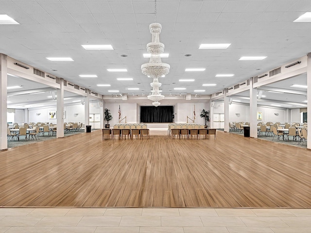 interior space with a chandelier, visible vents, and wood finished floors