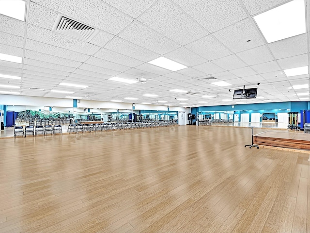 gym with visible vents, a drop ceiling, and wood finished floors