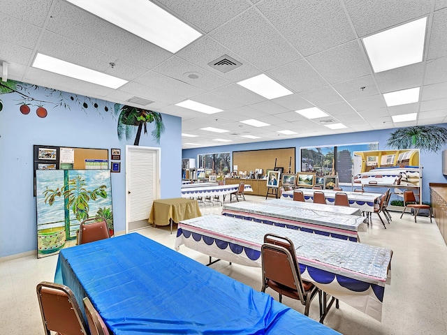 rec room with a paneled ceiling, visible vents, and baseboards