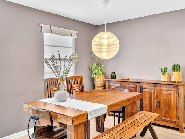 dining space with baseboards and light wood-style floors