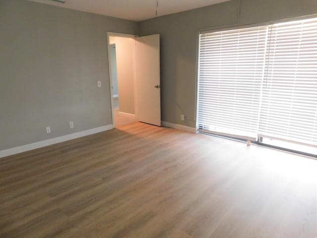 unfurnished room with hardwood / wood-style flooring