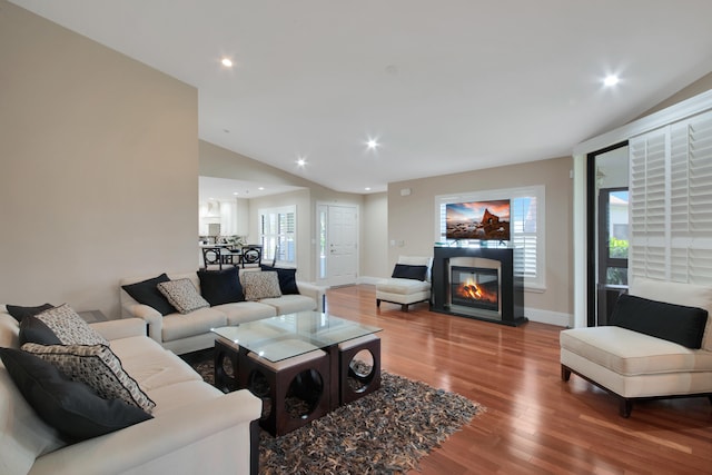 living room with hardwood / wood-style floors and lofted ceiling