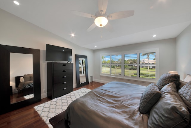 bedroom with dark hardwood / wood-style flooring, vaulted ceiling, and ceiling fan