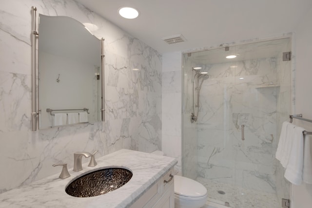 bathroom with vanity, backsplash, toilet, tile walls, and a shower with shower door