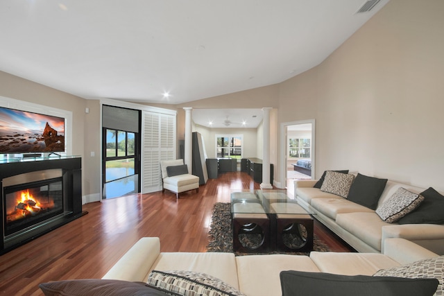 living room with decorative columns, vaulted ceiling, and hardwood / wood-style flooring