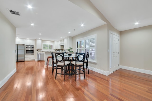 dining space with light hardwood / wood-style flooring