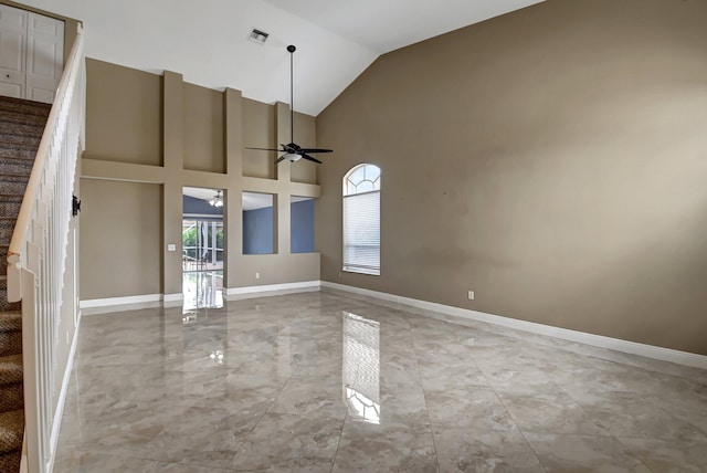 empty room with ceiling fan and high vaulted ceiling