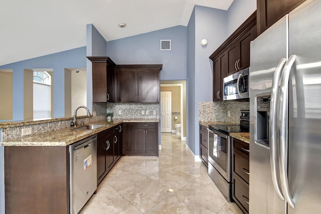 kitchen with appliances with stainless steel finishes, backsplash, lofted ceiling, and sink