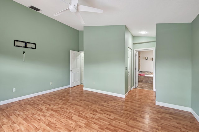 unfurnished room with ceiling fan, vaulted ceiling, and light wood-type flooring