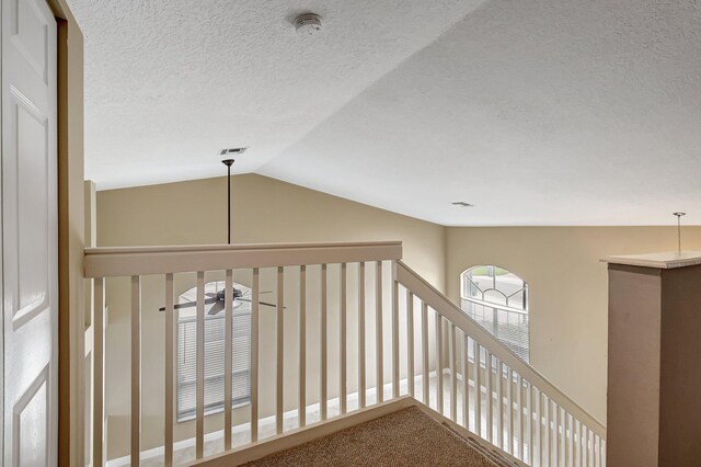 hall with carpet flooring and vaulted ceiling