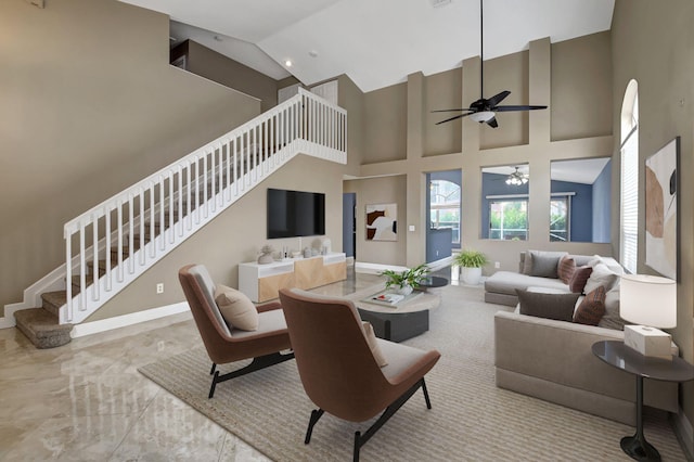 living room with a high ceiling and ceiling fan