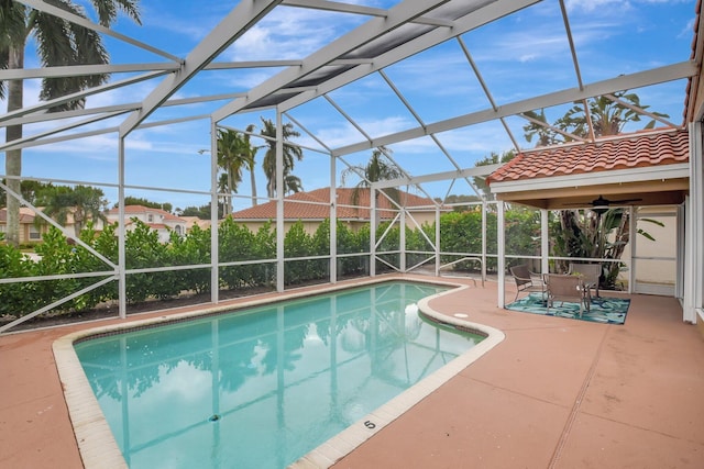 view of pool with glass enclosure and a patio area