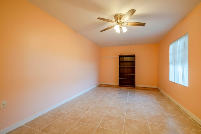 empty room with ceiling fan and light tile patterned floors