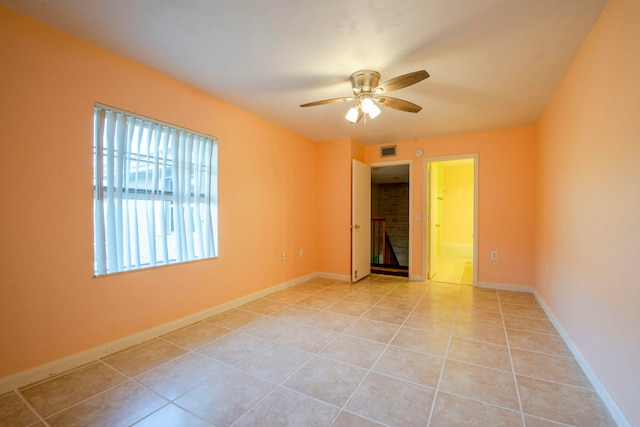 tiled spare room with ceiling fan