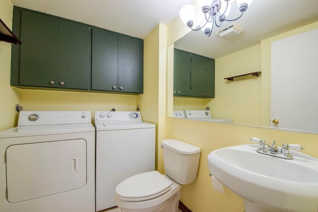 bathroom with toilet, washer and clothes dryer, a chandelier, and sink