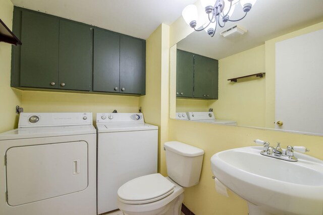 3537 SW Sunset Trace Cir, Palm City, FL 34990 - bathroom featuring washer and clothes dryer, toilet, a sink, and a chandelier