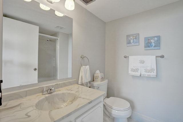 bathroom featuring vanity, toilet, and a shower with shower door