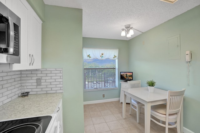 dining room featuring electric panel, light tile patterned floors, a textured ceiling, and a notable chandelier