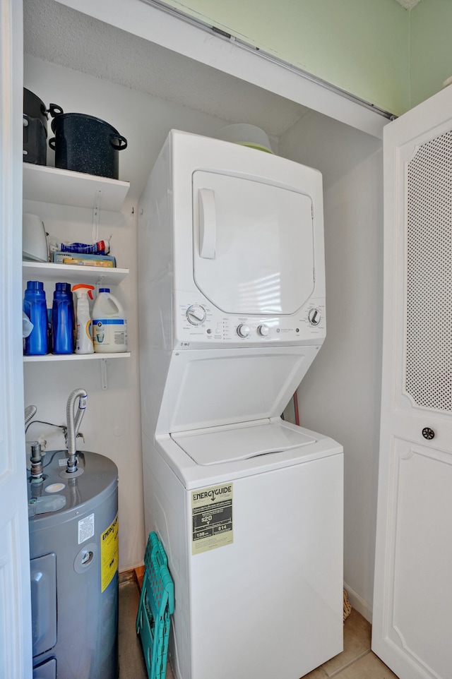 laundry area with light tile patterned floors, stacked washer / dryer, and water heater