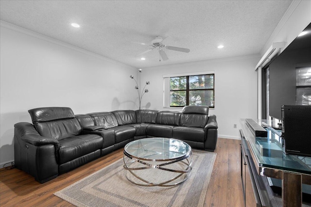 living room with ceiling fan, ornamental molding, a textured ceiling, and dark wood-type flooring