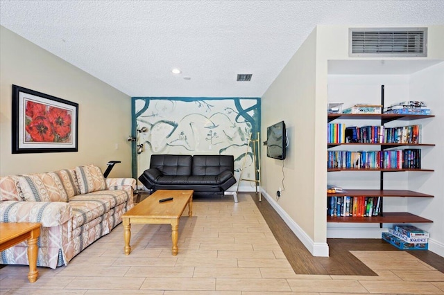 living room featuring a textured ceiling and light wood-type flooring