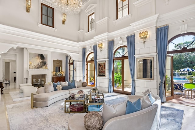 living room featuring french doors, plenty of natural light, a chandelier, and a high ceiling