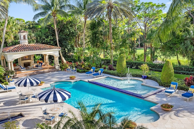 view of swimming pool featuring a jacuzzi and a patio