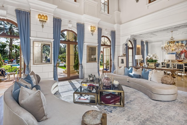 interior space with a high ceiling, french doors, a healthy amount of sunlight, and a notable chandelier