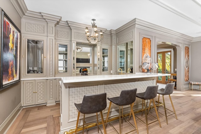 bar with decorative light fixtures, an inviting chandelier, and ornamental molding