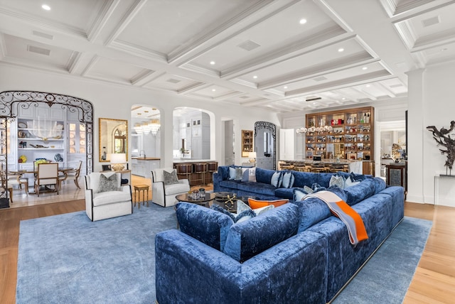 living room featuring ornamental molding, coffered ceiling, indoor bar, hardwood / wood-style flooring, and beamed ceiling