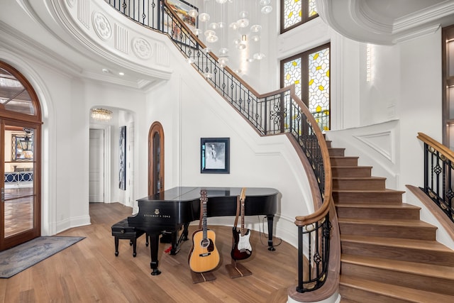 interior space with a high ceiling, hardwood / wood-style flooring, french doors, and ornamental molding