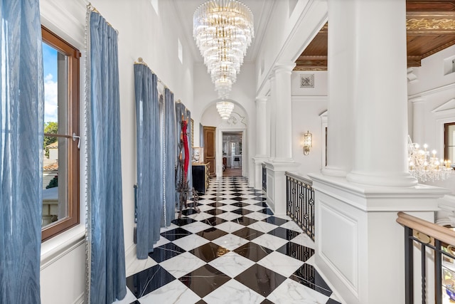 hall featuring ornamental molding and decorative columns