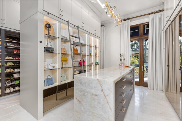 walk in closet with light tile patterned floors and french doors