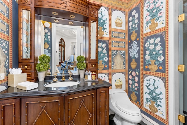 bathroom with vanity, toilet, and crown molding