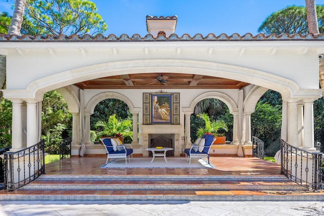 view of patio / terrace with exterior fireplace and ceiling fan