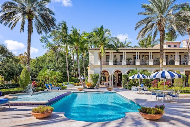 view of swimming pool featuring pool water feature and a patio area