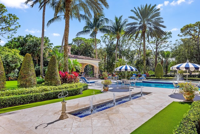 view of swimming pool with pool water feature and a patio area