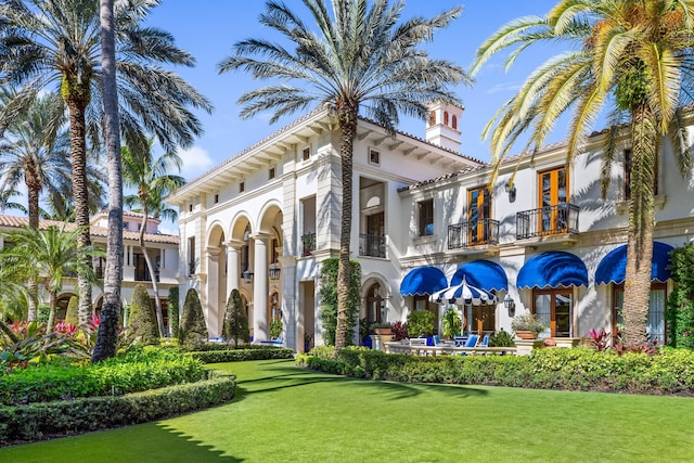 view of front facade with a balcony and a front yard